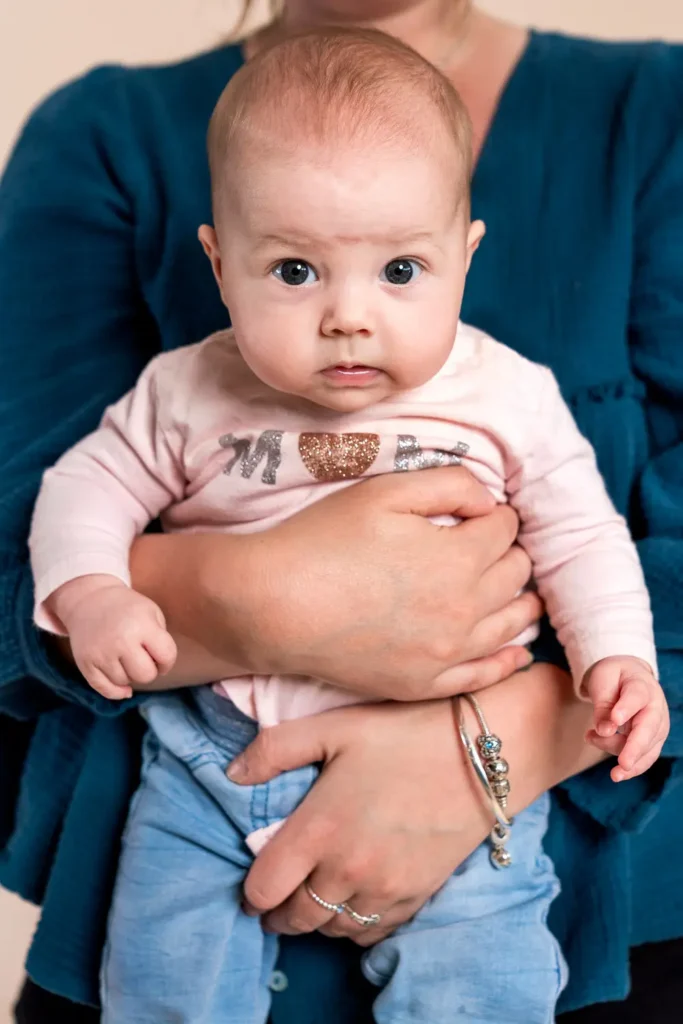 Close-up portrait of a baby held by a parent for annual report photography
