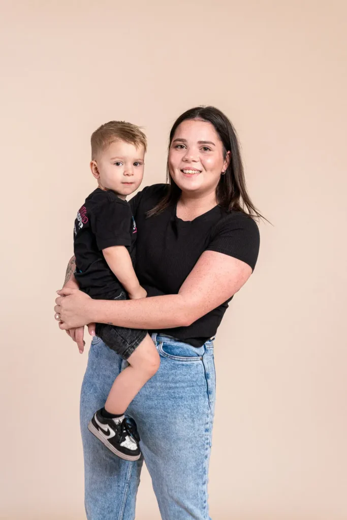 Parent holding a young child in a studio portrait for annual report photography