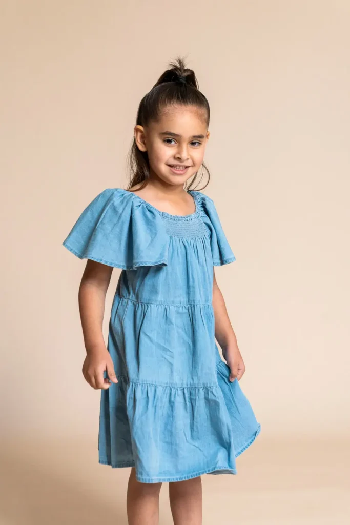 Portrait of a young child in a blue dress photographed for the Karitane annual report