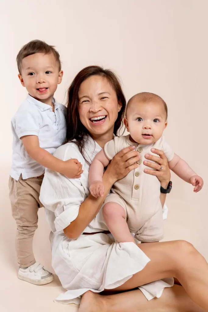 Mother with children smiling in a studio portrait for Karitane annual report photography