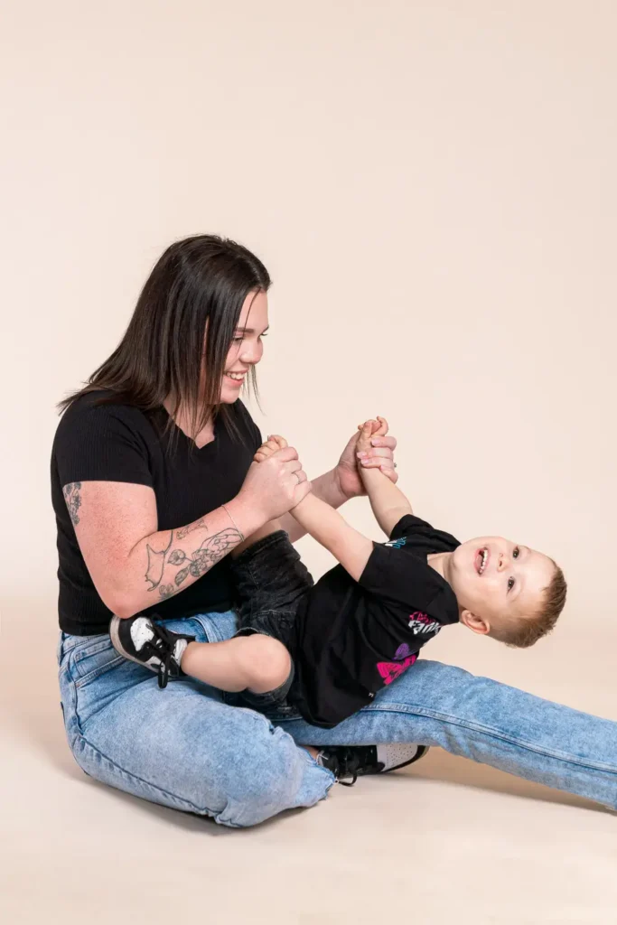 Parent playing with a toddler in a relaxed studio portrait for Karitane annual report photography