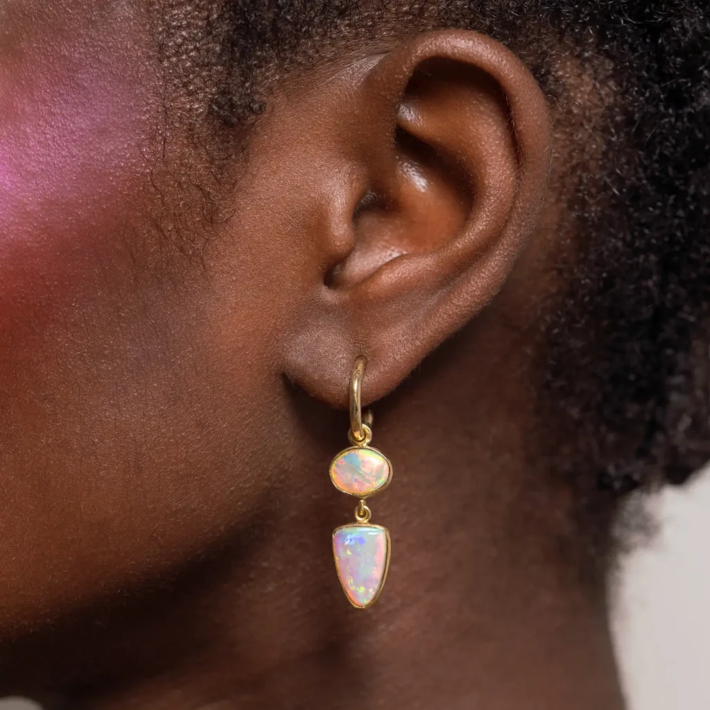 Model wearing statement gold opal earrings close-up