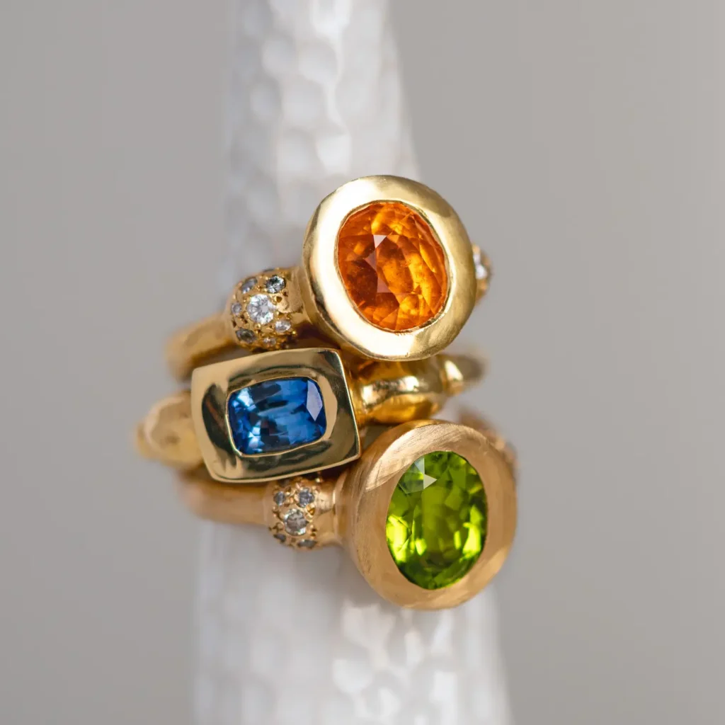 green, blue and orange gold tourmaline and diamond rings photographed in studio