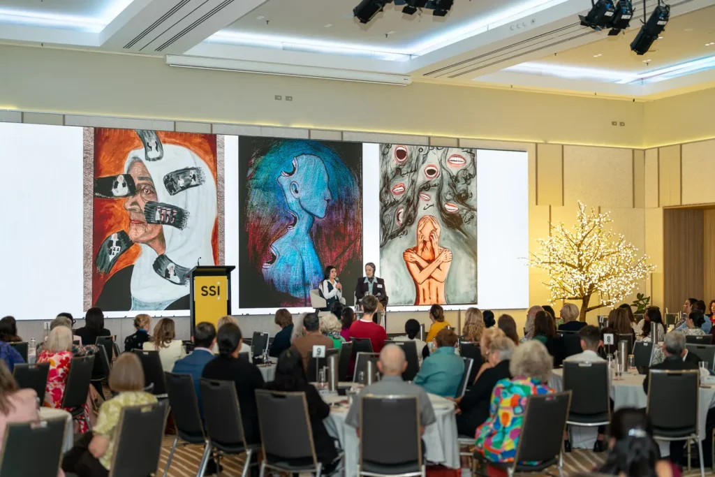 Stage view with artwork and illuminated tree at the Silence to Power event at PARKROYAL Parramatta
