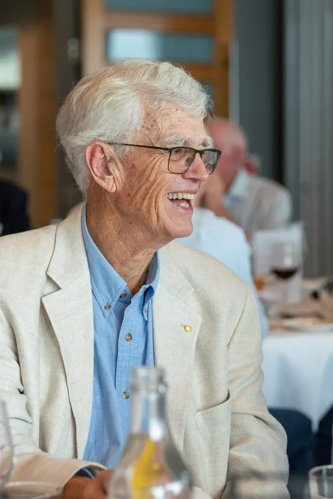 Michael Morgan OAM seated and smiling during the lunch in his honour