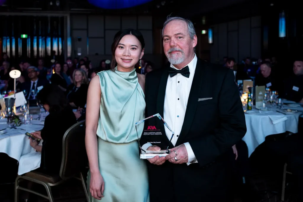 Award winners posing with trophy at the Australasian Reporting Awards gala dinner