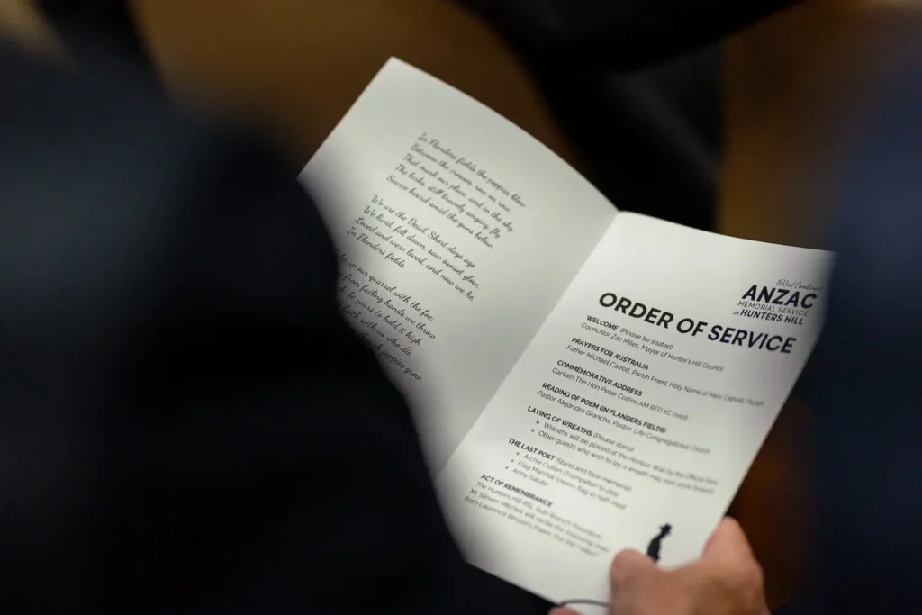 Close-up of attendee reading Order of Service booklet during Hunters Hill ANZAC memorial ceremony