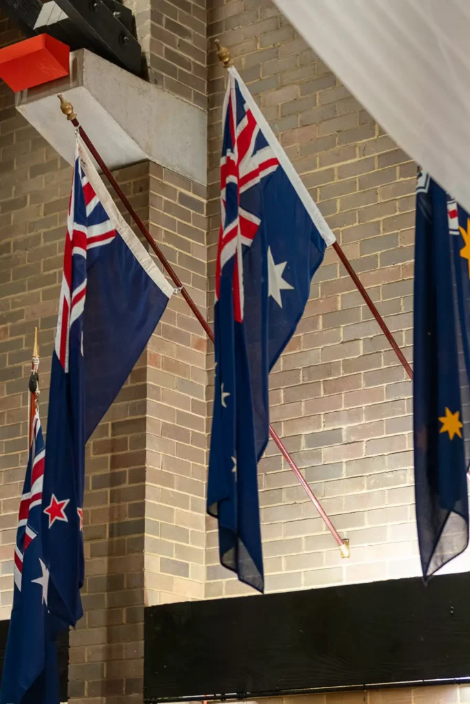 Australian and New Zealand flags hanging inside memorial hall during ANZAC service