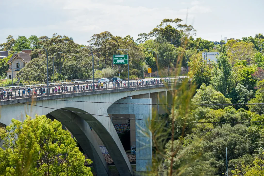 Long line of participants walking across a bridge during the Sydney Bridges Walk