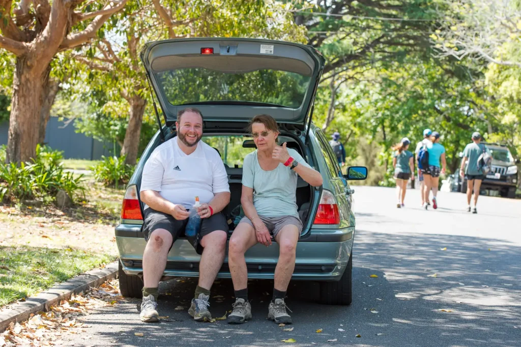 Participants resting beside the walking route during the Bridges Walk in Sydney