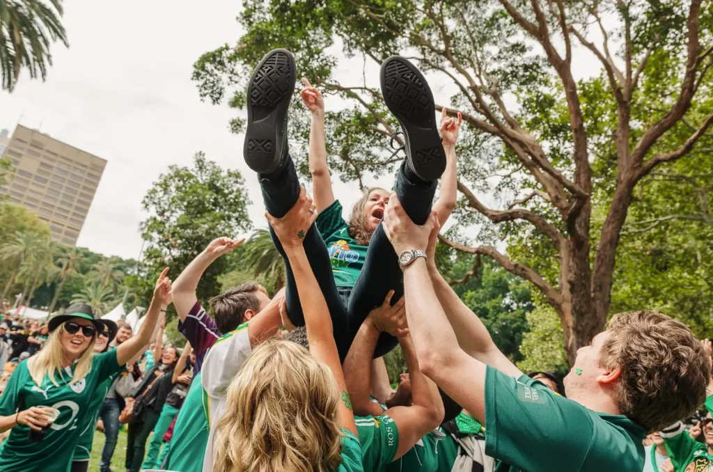 Festival crowd lifting woman during energetic St Patrick’s Day celebration