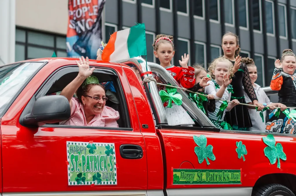 Family and children waving from decorated parade float at Sydney St Patrick’s Day celebrations