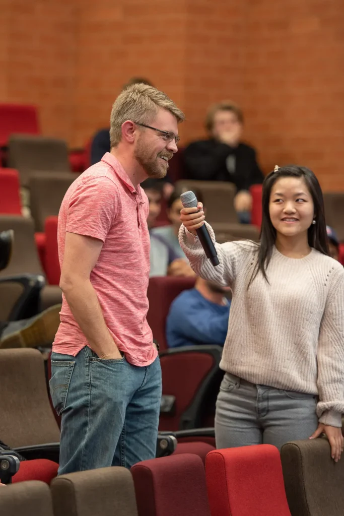 Audience member speaking into a microphone during the University of Sydney debate