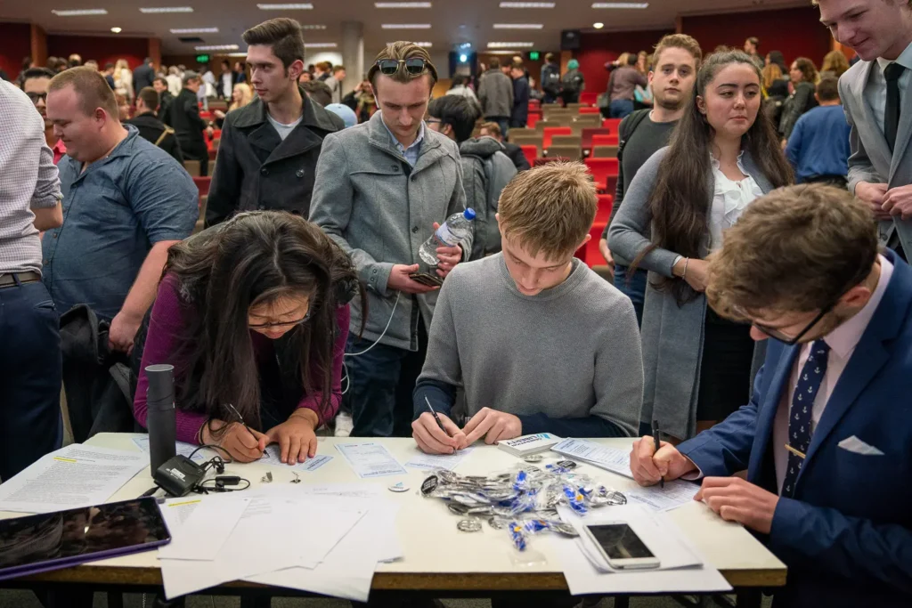 Conference attendees filling out registration forms at a table
