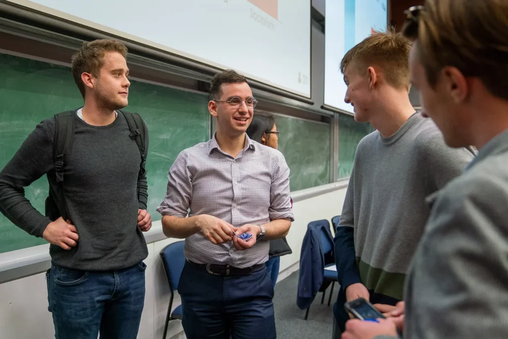 Male conference speaker chatting with attendees after his presentation