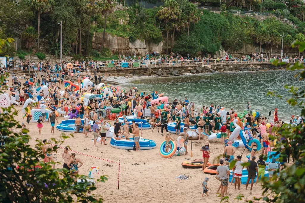 Large crowd of participants and colourful inflatables gathered on Shelly Beach before the race