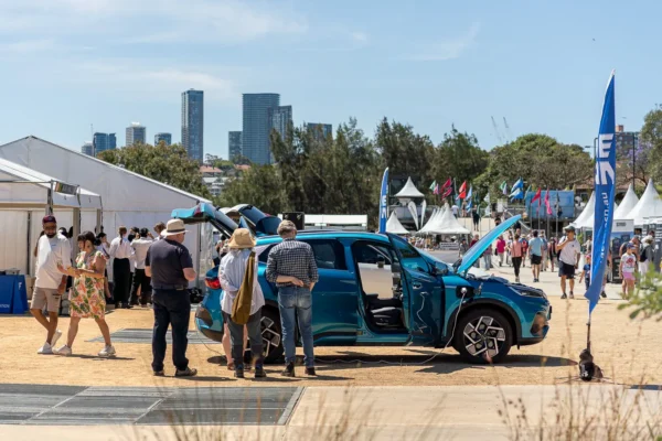 Electric vehicle on display with doors open at an outdoor sustainability festival