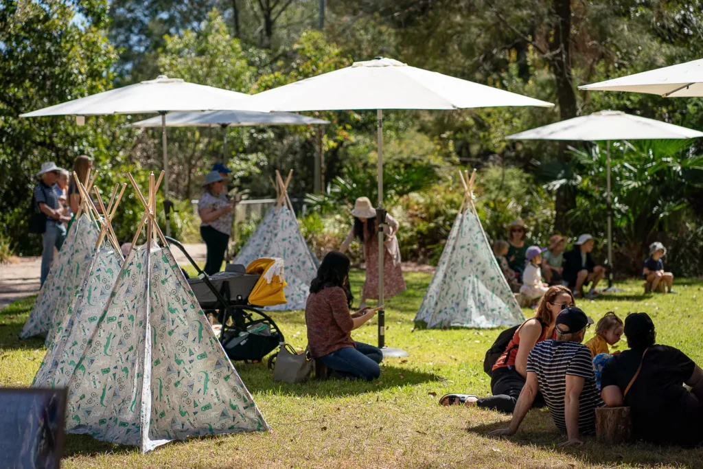 Families relaxing in the shaded kids area at the Coal Loader Sustainability Festival in Waverton