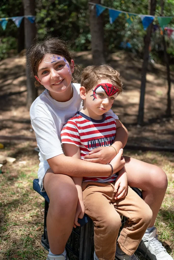 Children with colourful face painting enjoying an outdoor sustainability festival