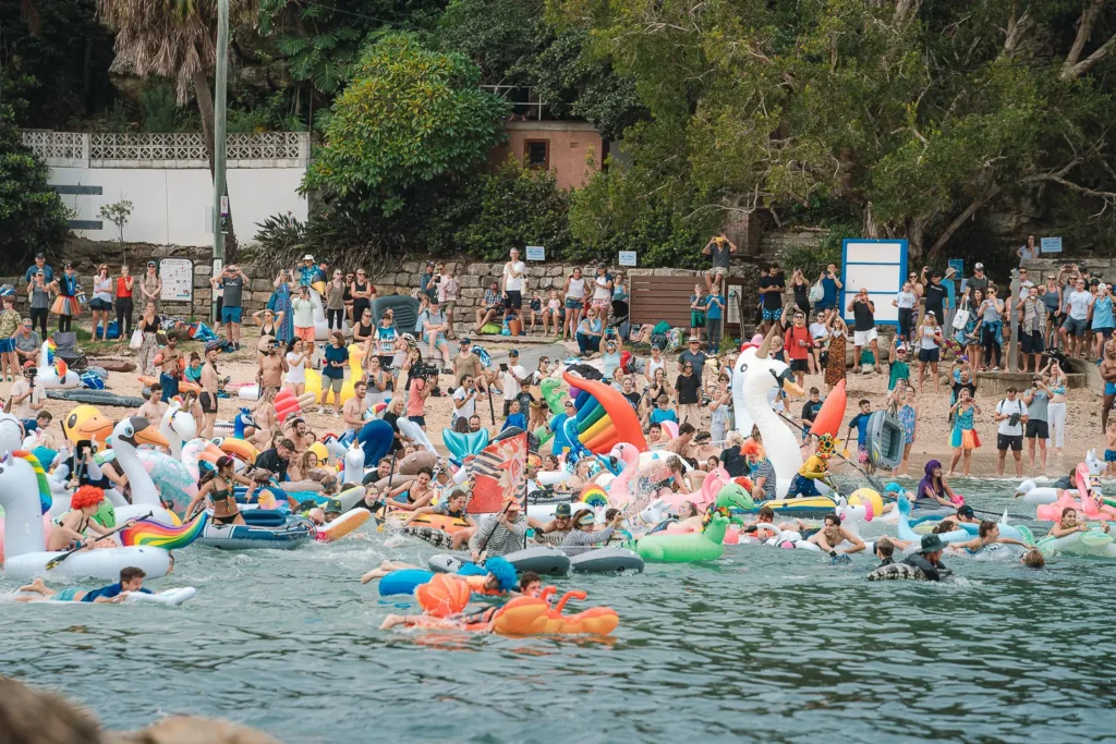 Hundreds of participants launching colourful inflatables into the water at Shelly Beach