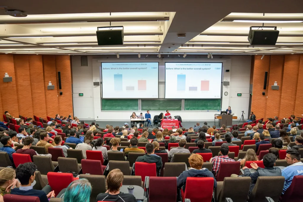 Wide view of a packed lecture theatre during a conference session
