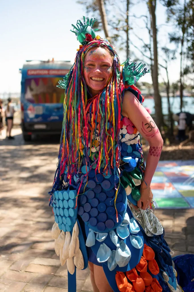 Festival performer wearing a colourful costume made from recycled materials