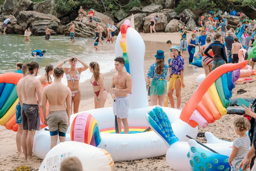 Participants gathering around a giant white swan inflatable before the race at Shelly Beach