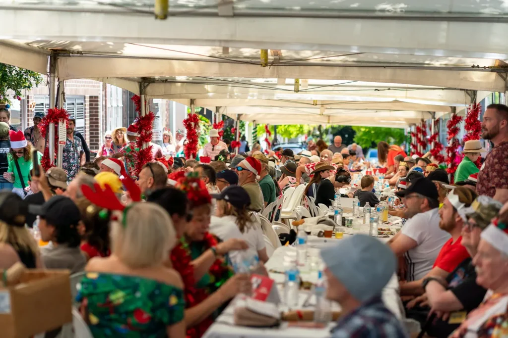 Long communal tables filled with guests at the Wayside Chapel Christmas lunch