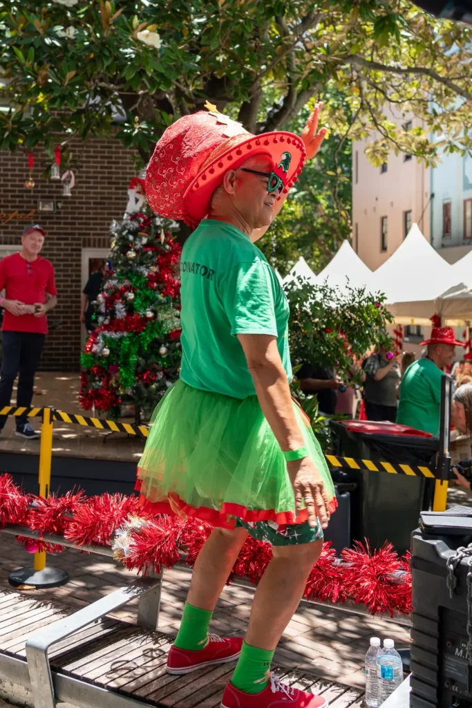Guest wearing a colourful Christmas hat and green festive outfit at Wayside Chapel