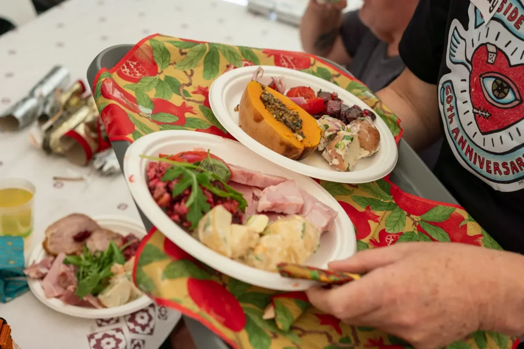 Plates of Christmas lunch food being served to guests at Wayside Chapel