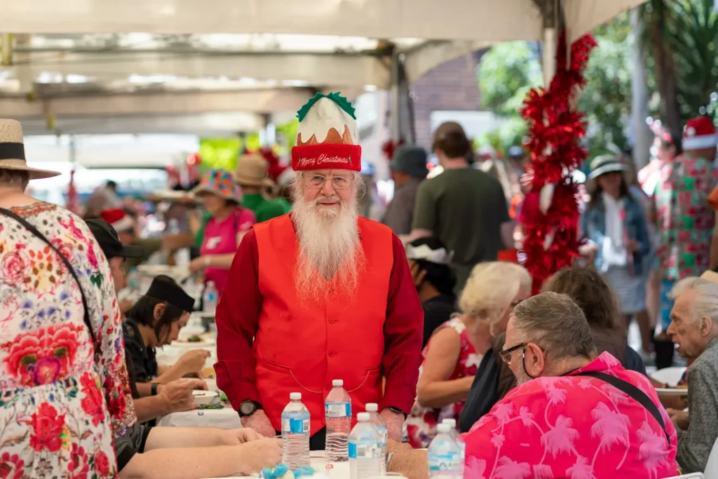 Bearded guest dressed in festive red at the Wayside Chapel community Christmas lunch