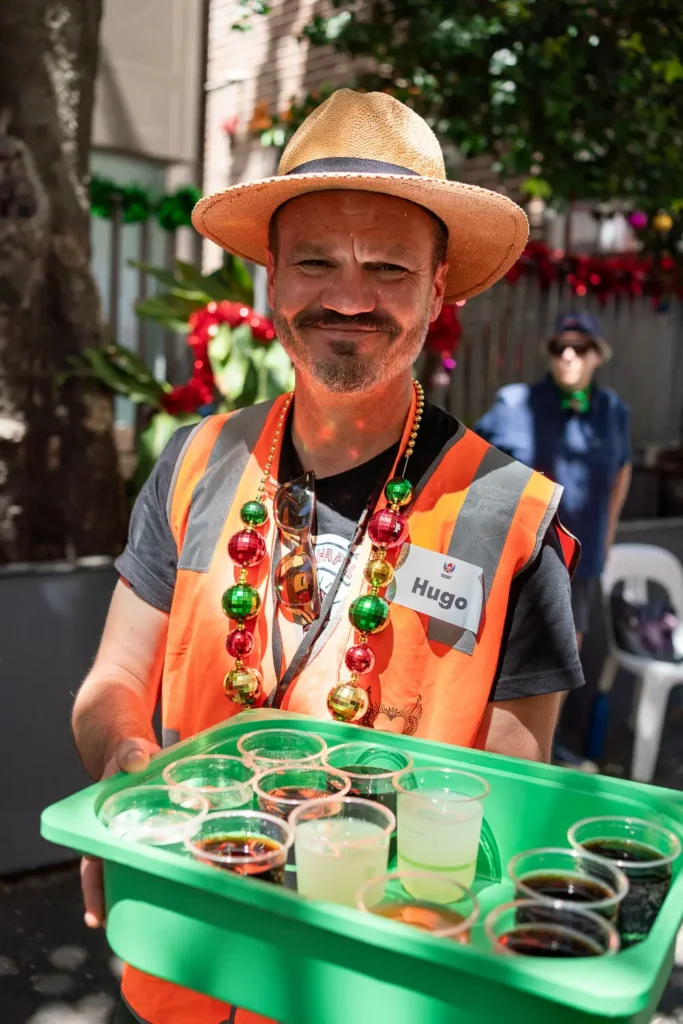 Wayside Chapel Christmas volunteer serving drinks during the community event in Sydney