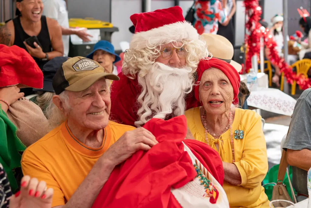 Santa spending time with guests at the Wayside Chapel Christmas community celebration
