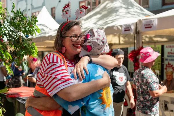 Wayside Chapel volunteer sharing a warm hug during the Christmas Day community celebration