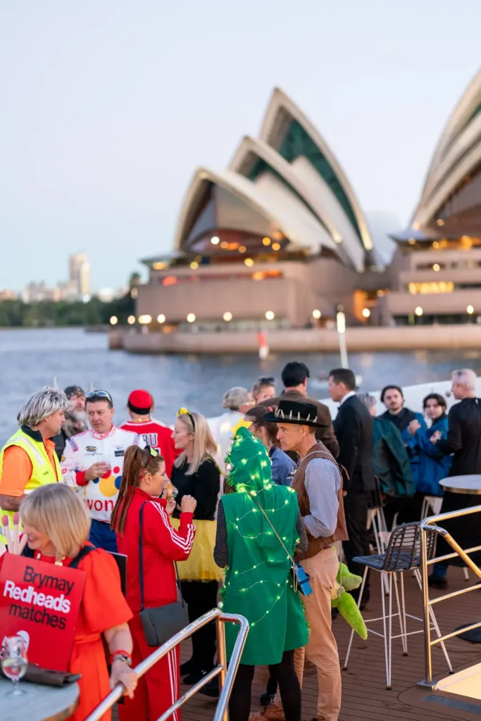 Costumed guests socialising at a corporate event overlooking the Sydney Opera House