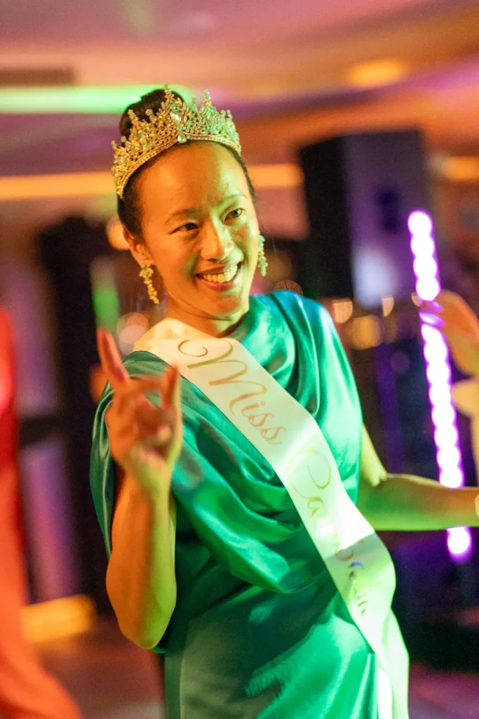 Guest wearing a crown and sash dancing at a corporate costume party in Sydney