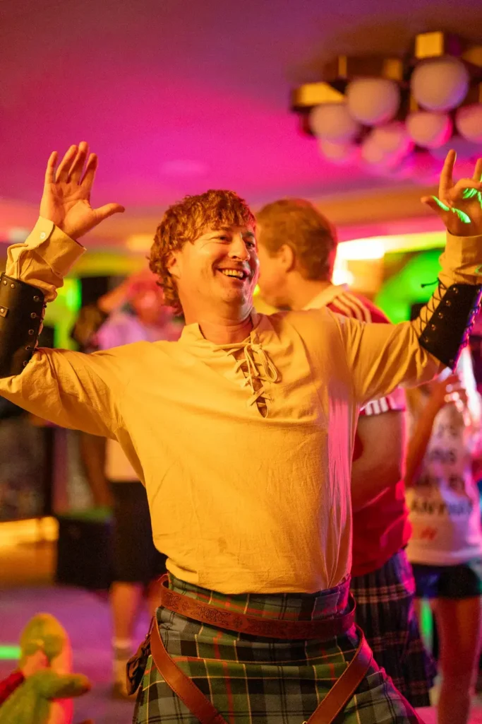 Guest dancing in costume under colourful event lighting in Sydney