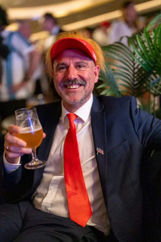 Smiling guest in a red cap holding a drink at a Sydney corporate event