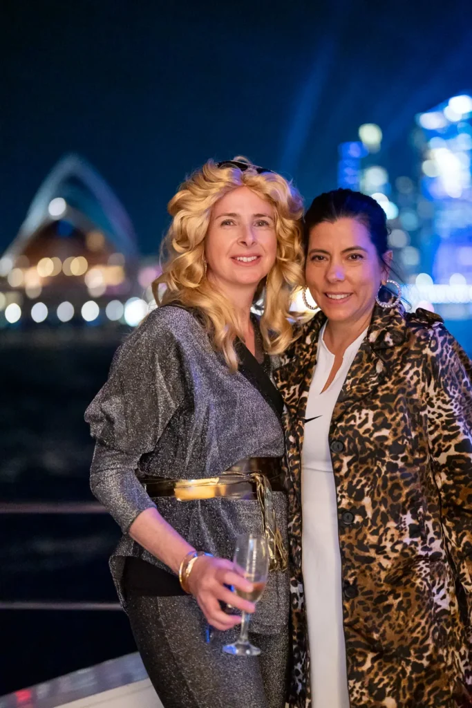 Two guests posing at a corporate event with Sydney Harbour at night