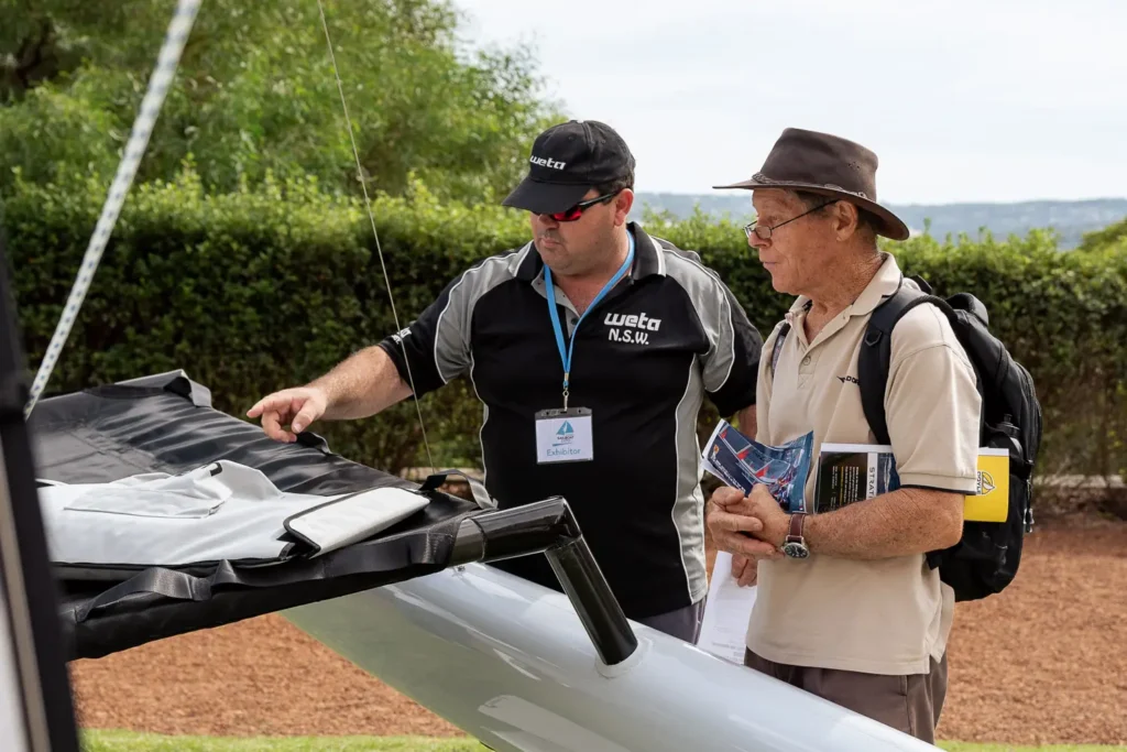Exhibitor demonstrating sailing equipment during a Sydney expo event
