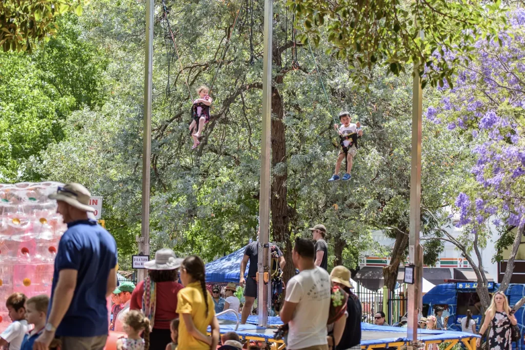 Children enjoying a bungee trampoline ride at Glebe Street Fair, captured during Sydney community event photography
