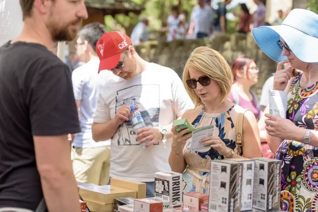 Festival visitors browsing products and speaking with a stallholder at Glebe Street Fair Sydney