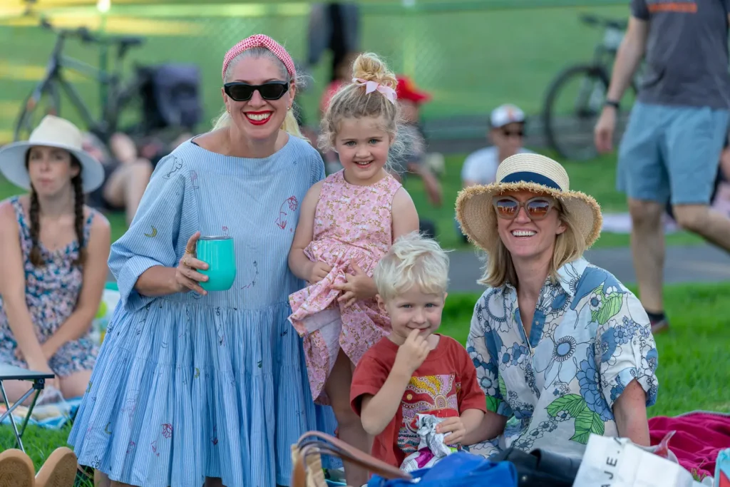 Smiling families enjoying the outdoor Sunset Series music event at Waverton Park