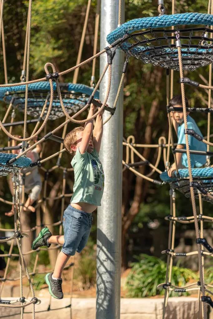 North Sydney event photography capturing a child climbing at the St Leonards Park playground opening