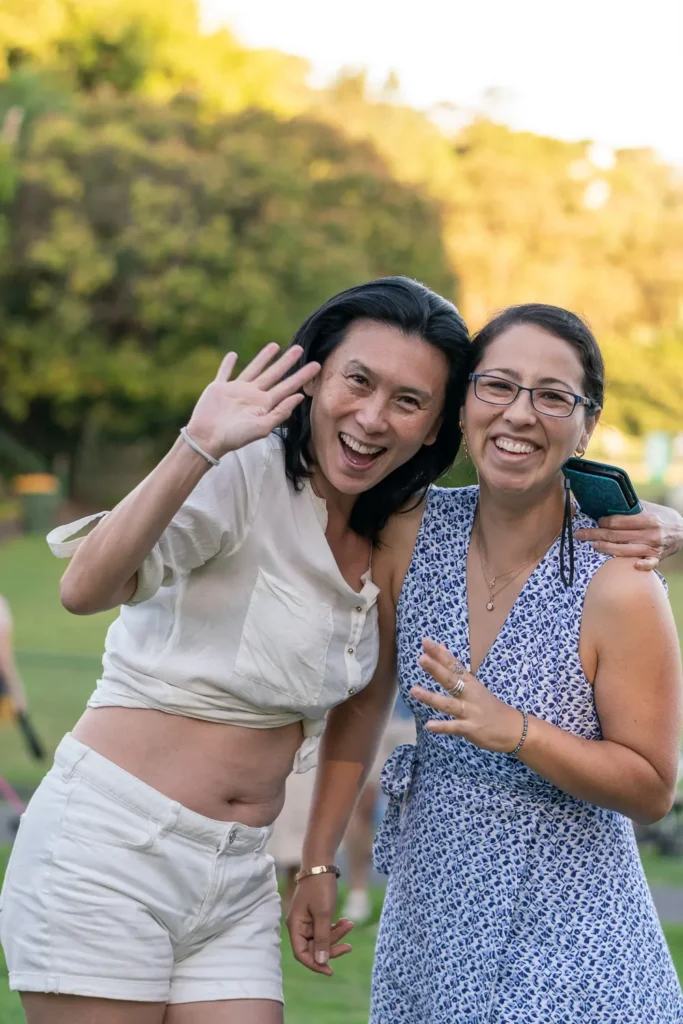 Two smiling friends posing together at Sunset Series 2022 in Waverton Park