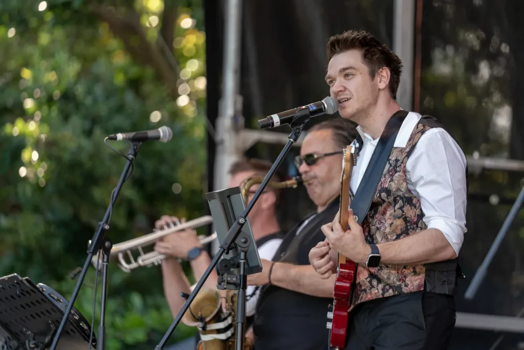 Guitarist and brass musicians performing live at Sunset Series 2022 in North Sydney
