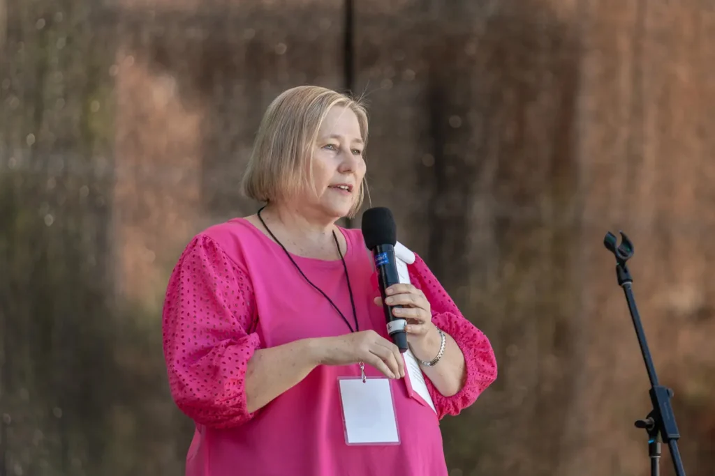 Woman in pink addressing the audience at North Sydney Sunset Series 2022 in Waverton Park