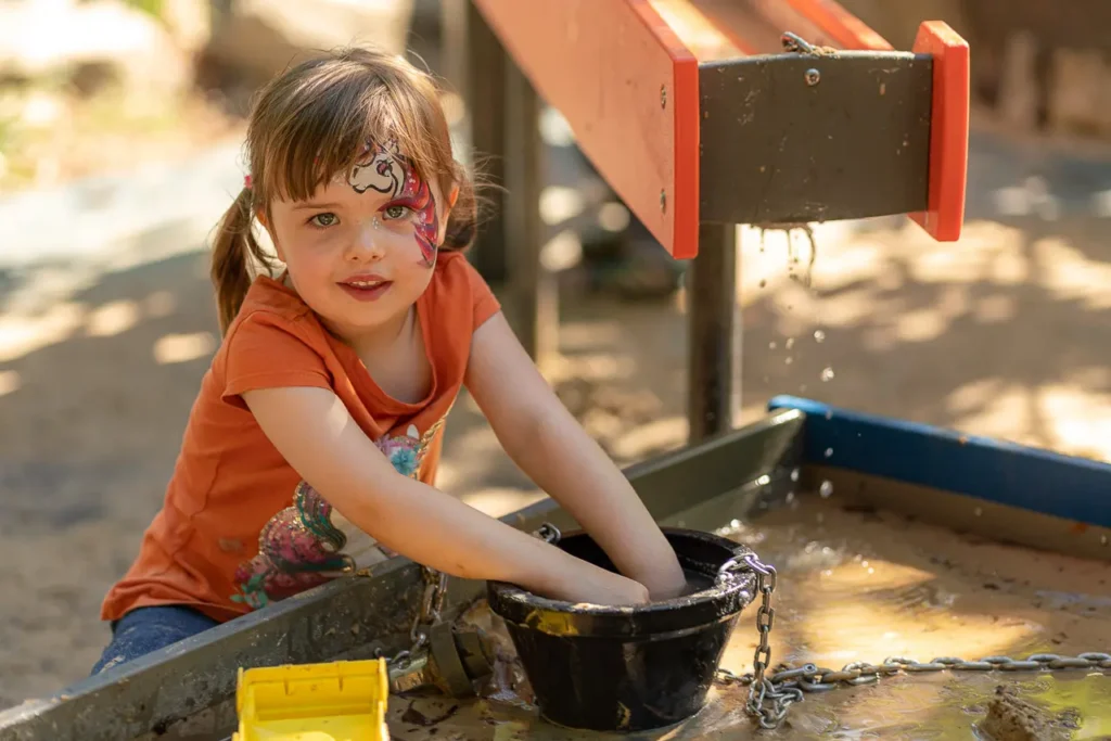 Event photography capturing a child enjoying water play at the St Leonards Park playground opening
