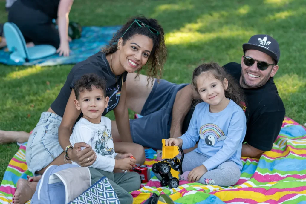 Family of four relaxing on a colourful picnic blanket during Sunset Series 2022