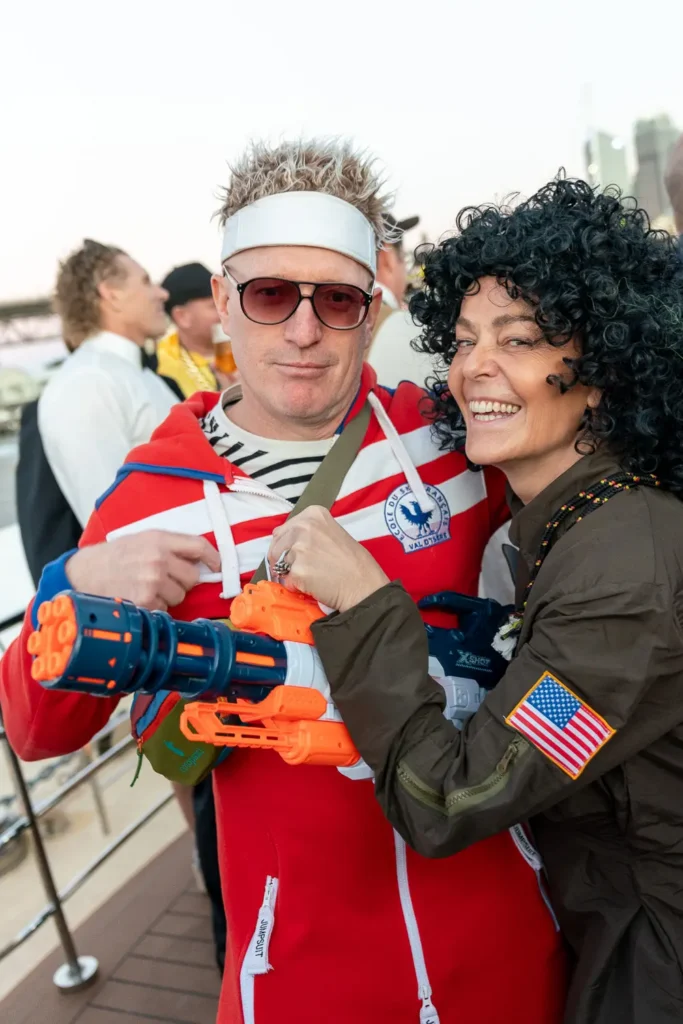 Guests in colourful costumes posing together at a Sydney corporate party